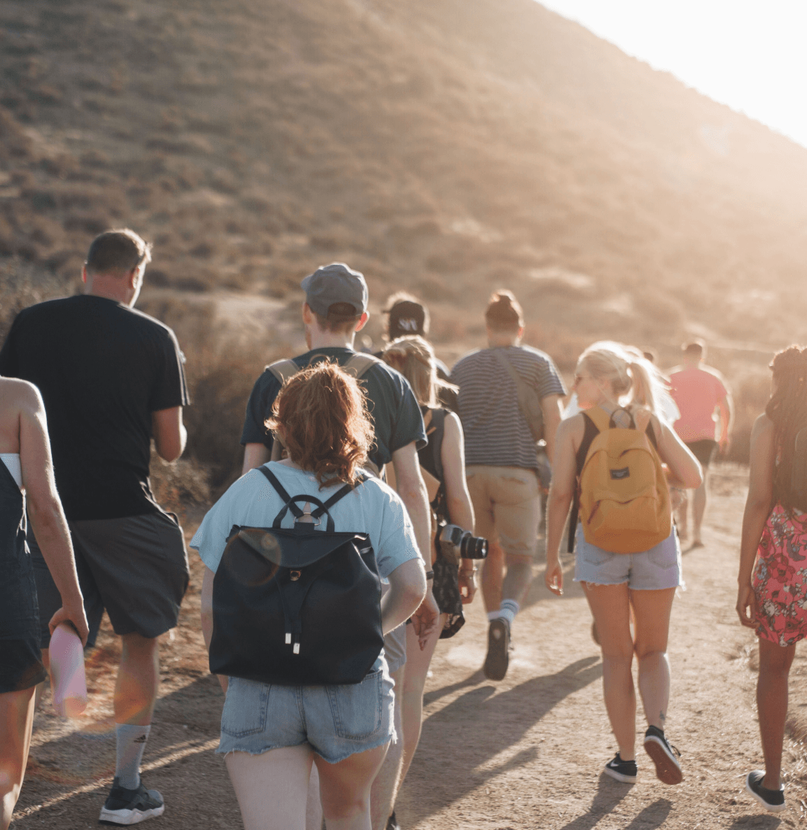 A diverse group of individuals walking along a dusty path, embodying the golden rule of transparency, helpfulness, and respect.